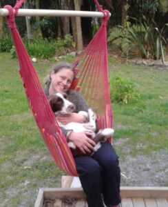 Kate on a hammock with her dog Scout.